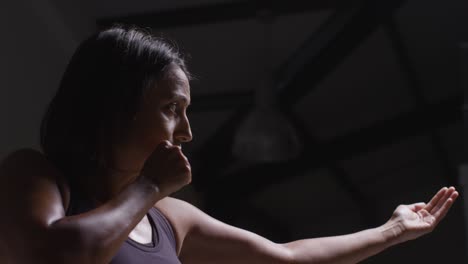 Profile-Shot-Of-Mature-Woman-Wearing-Gym-Fitness-Clothing-Exercising-Beckoning-Sparring-Partner